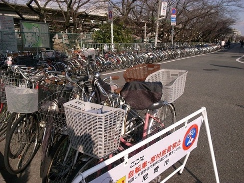 武庫之荘駅前の放置禁止看板の横にずらりと並ぶ、放置自転車の列（2009年撮影）