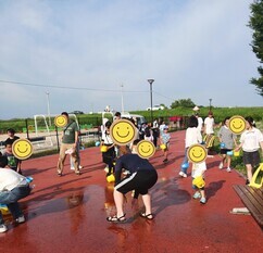 打ち水で水にぬれる参加者