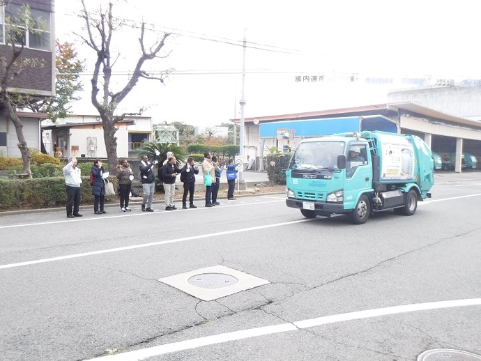 出庫するごみ収集車に手を振っています。