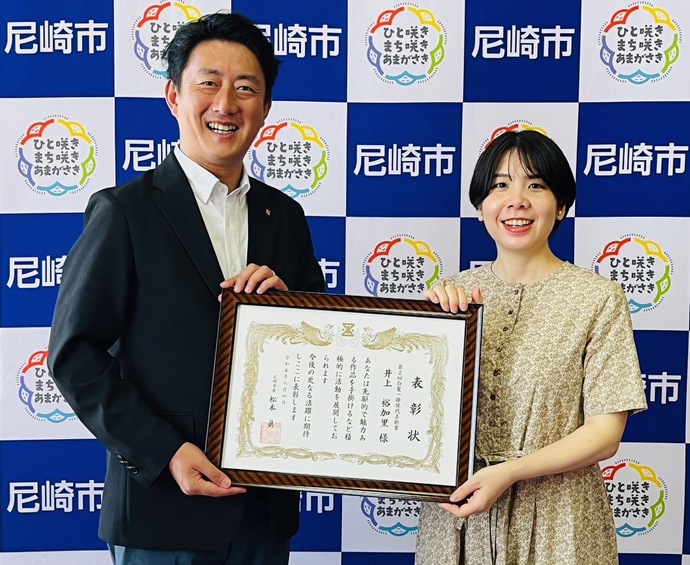 表彰状を持つ、市長と井上裕加里さん