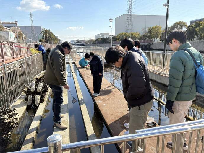 水質浄化施設で水路の説明を受ける様子
