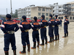 雨の中で整列する団員