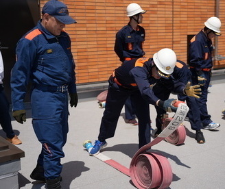 消防ホースを伸ばす団員