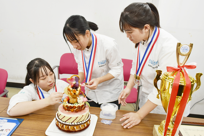 真剣な表情でケーキの調整をするチームの皆さん