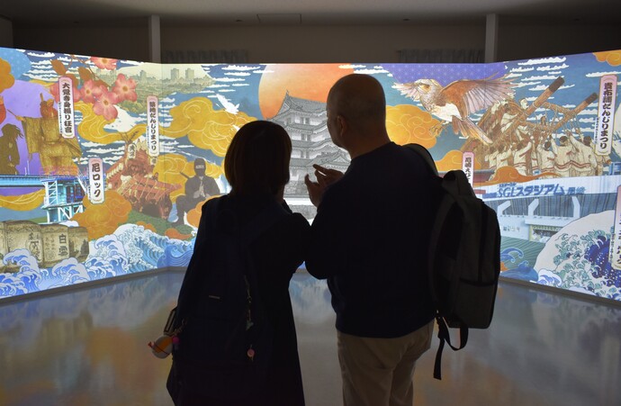 夫婦でスクリーンを視聴している写真